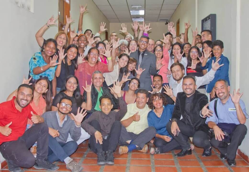 Parte del equipo conformado por hombres y mujeres saludando en LSV